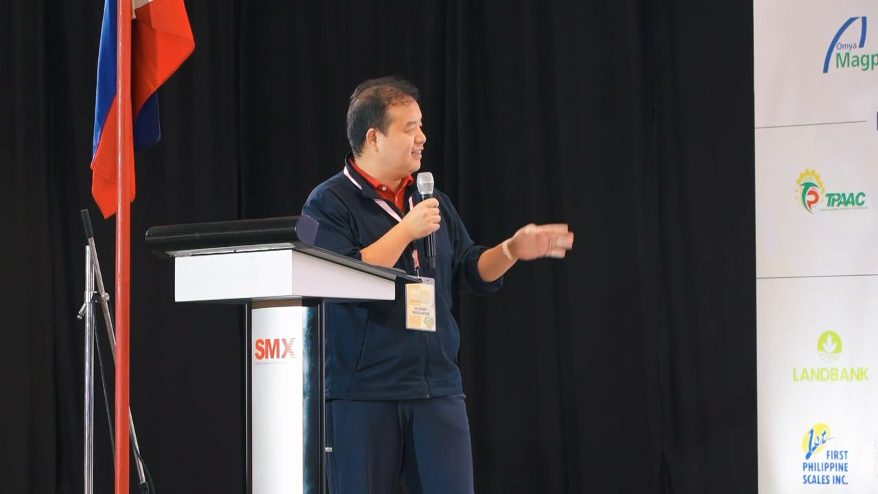 A speaker addressing the audience from the conference stage.